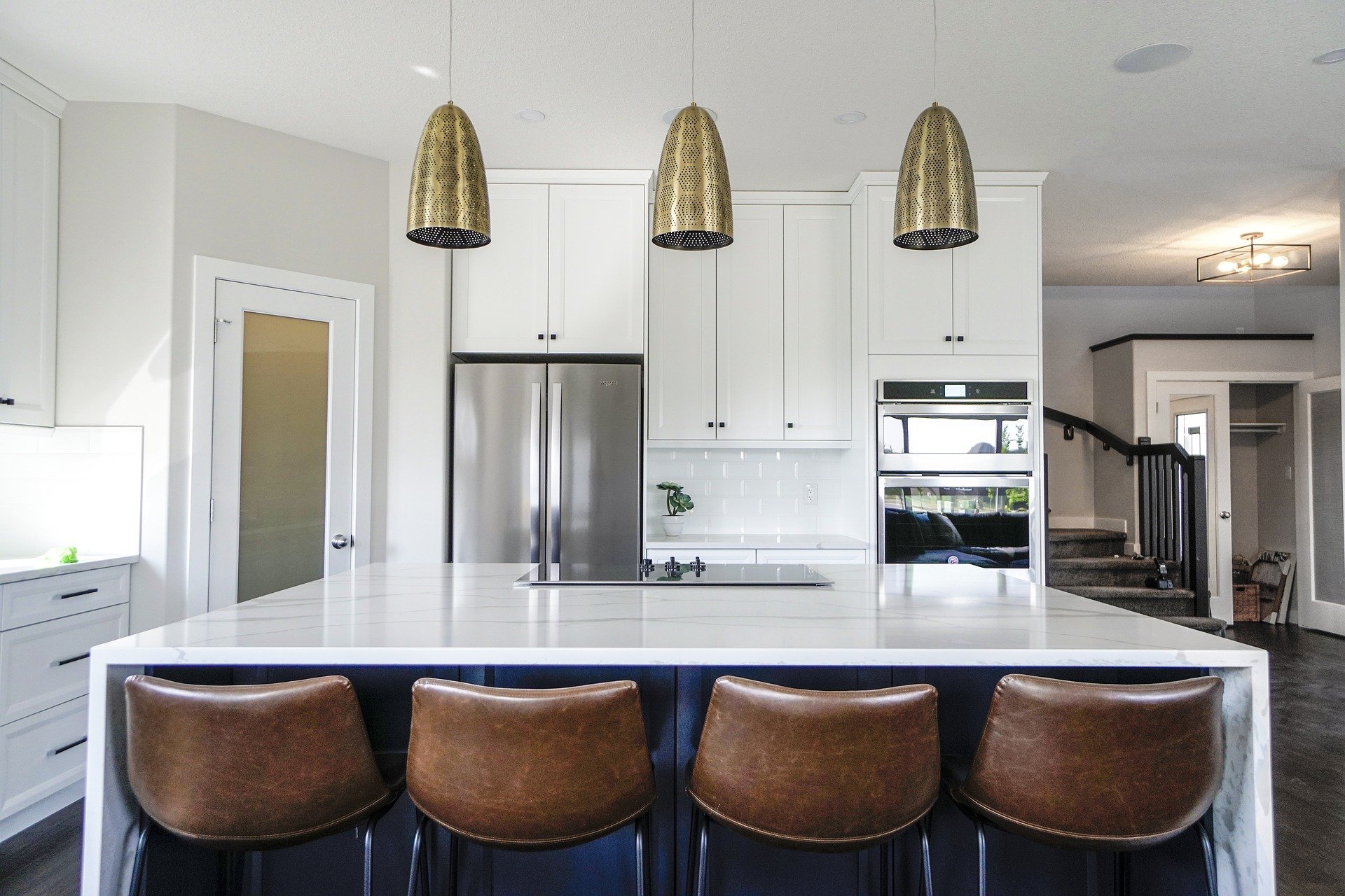 transitional white kitchen white slab quartz island